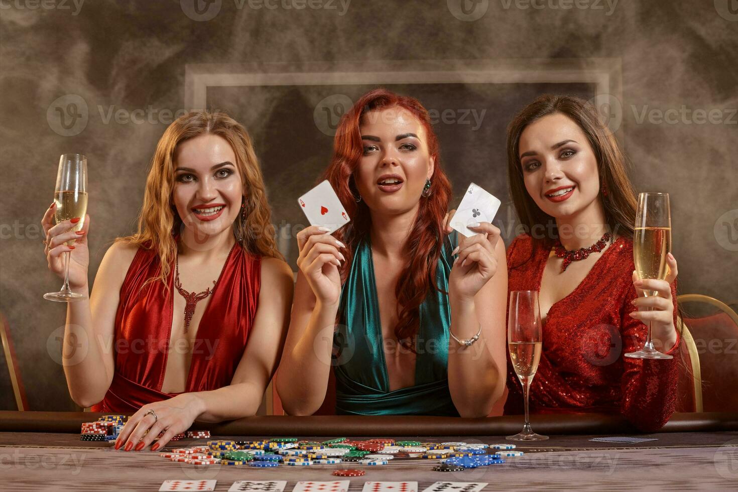 Group of a young wealthy ladies are playing poker at a casino. photo