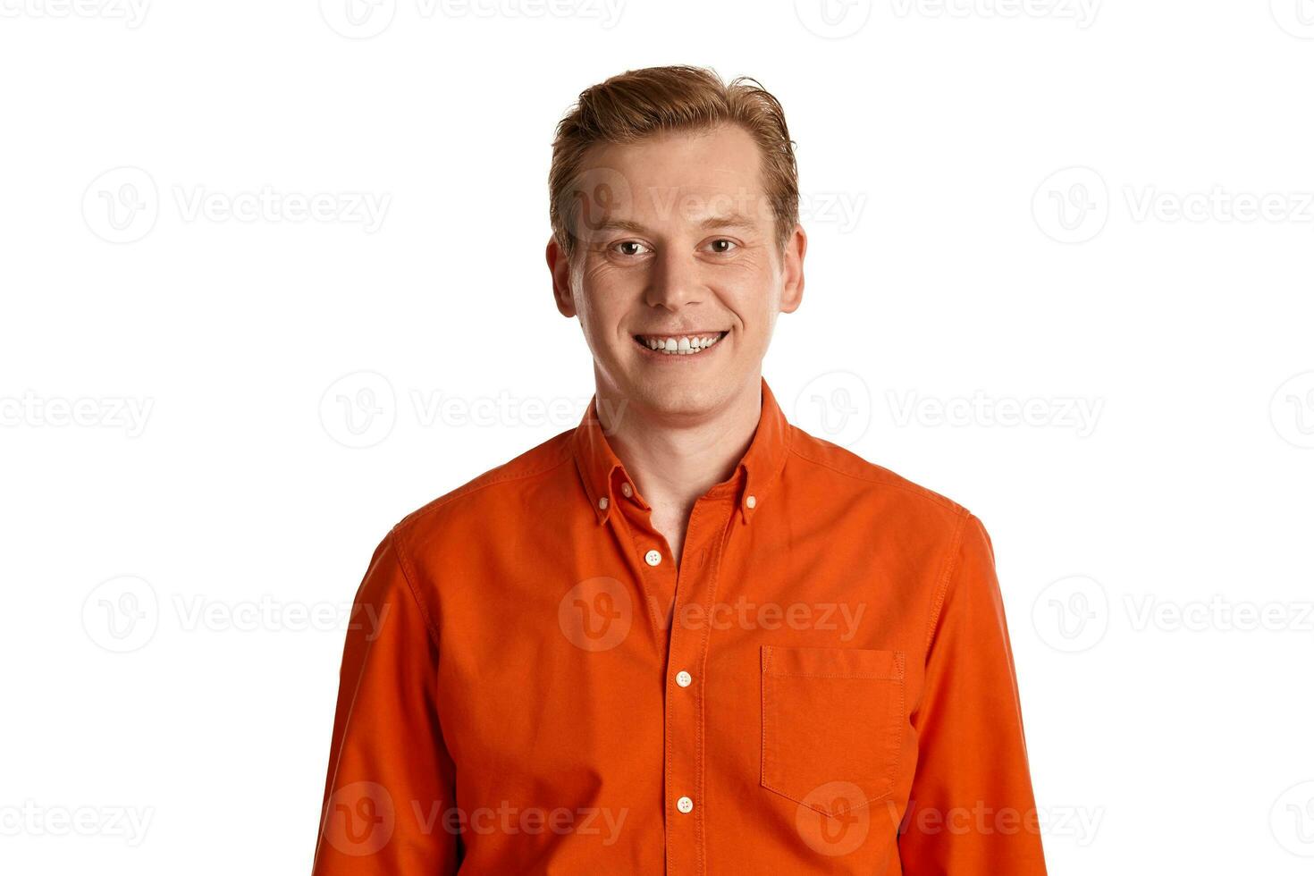 de cerca retrato de un jengibre chico en naranja camisa posando aislado en blanco antecedentes. sincero emociones foto