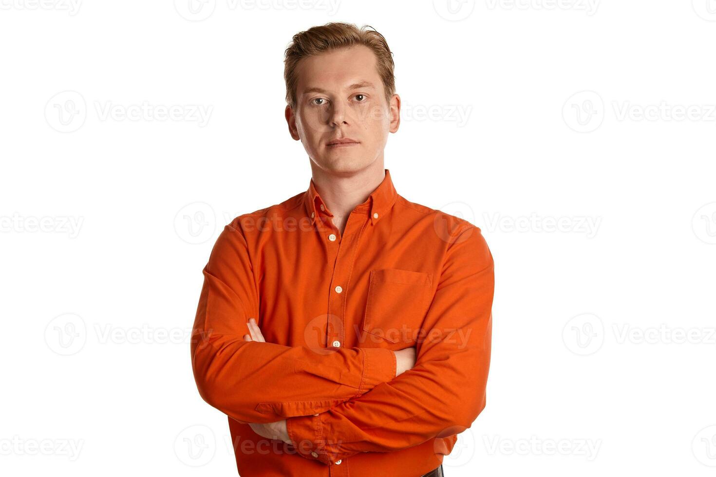Close-up portrait of a ginger guy in orange shirt posing isolated on white background. Sincere emotions. photo