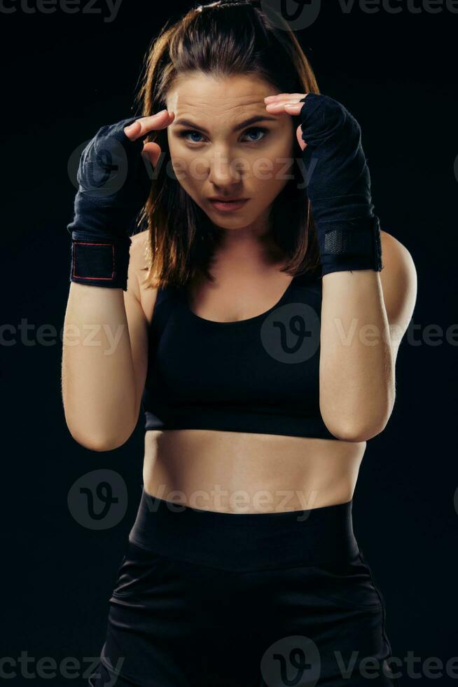 Athletic woman in boxing mittens is practicing karate in studio. photo