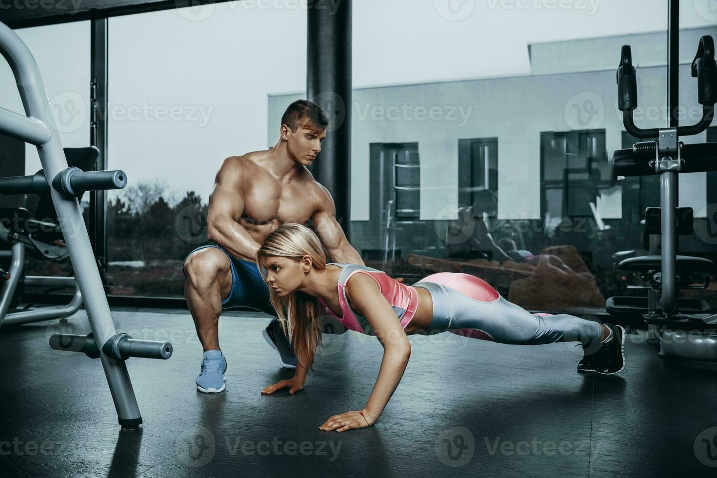 Sportive woman doing plank exercise training back and press muscles with trainer. Sport fitness workout strength power concept. photo