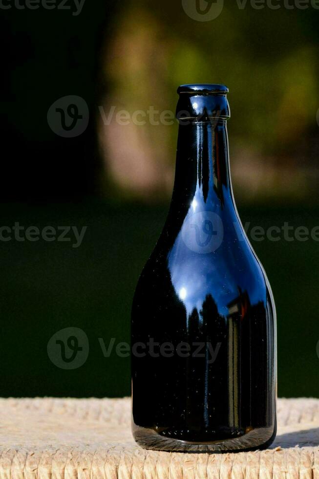 a black bottle sitting on top of a wooden table photo