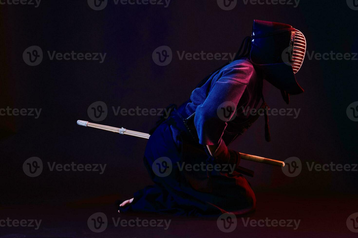 cerca arriba disparo, kendo combatiente vistiendo en un armadura, tradicional kimono, casco practicando marcial Arte con shinai bambú espada, negro antecedentes. foto