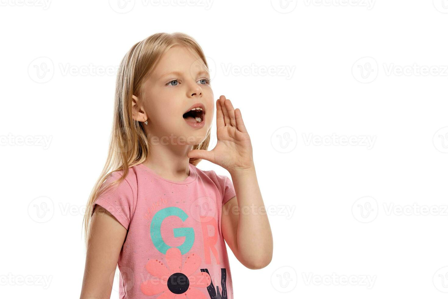 Close-up portrait of a nice blonde little kid in a pink t-shirt posing isolated on white background. photo