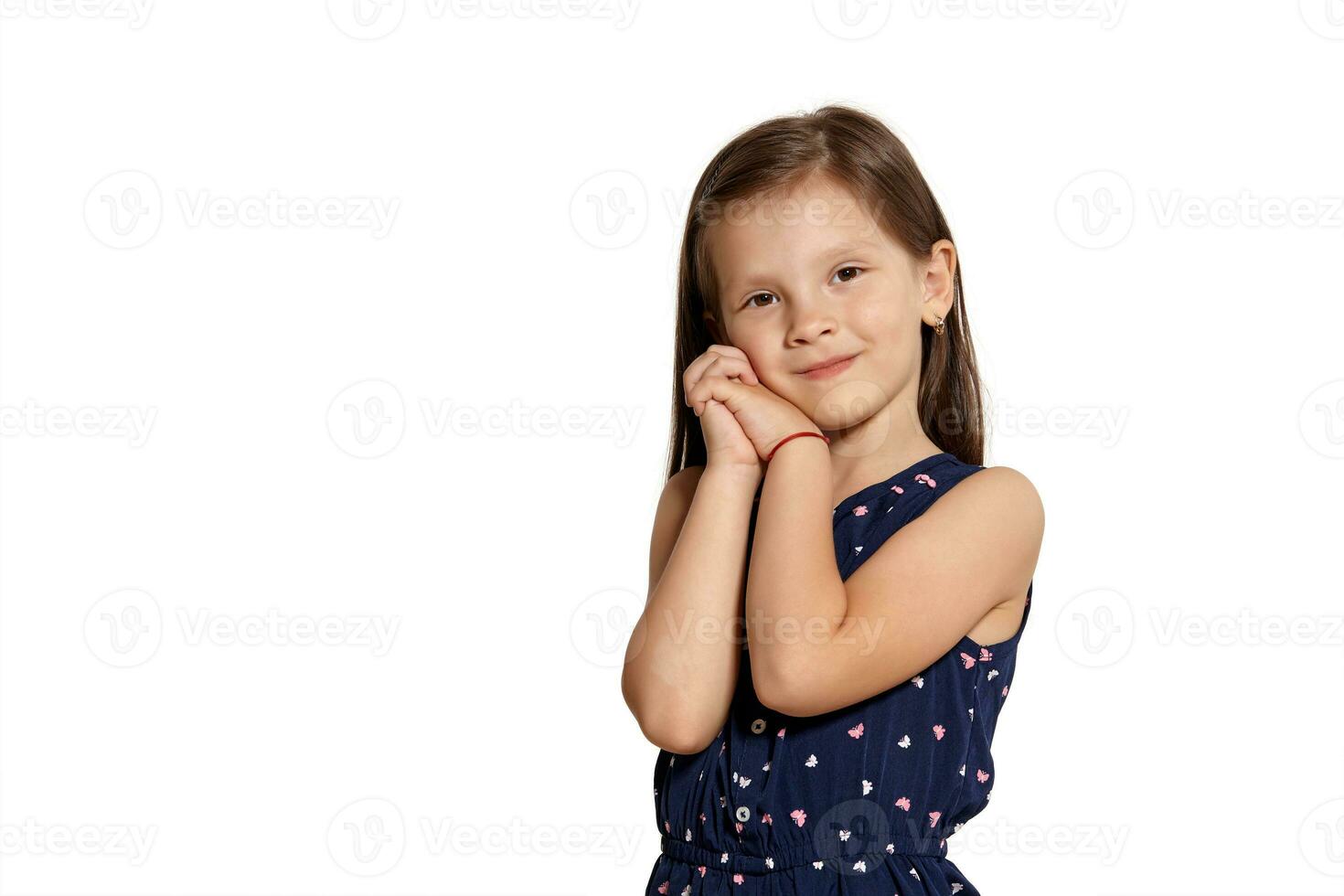 Close-up studio shot of beautiful brunette little girl posing isolated on white studio background. photo