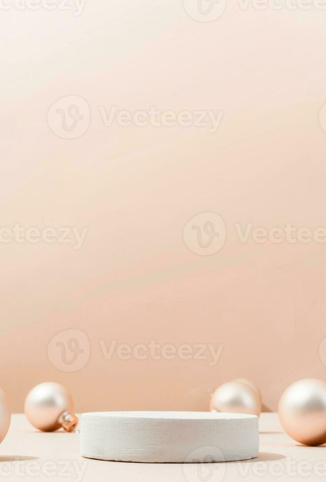 A minimalistic scene of a podium with christmas decorative balls on beige background photo