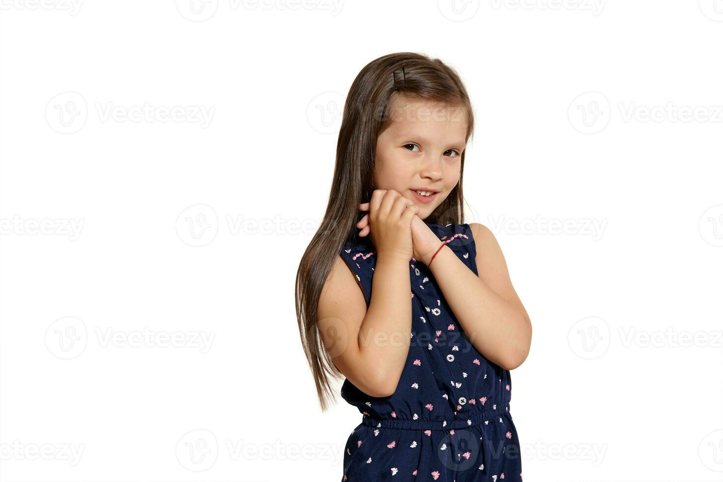 Close-up studio shot of beautiful brunette little girl posing isolated on white studio background. photo