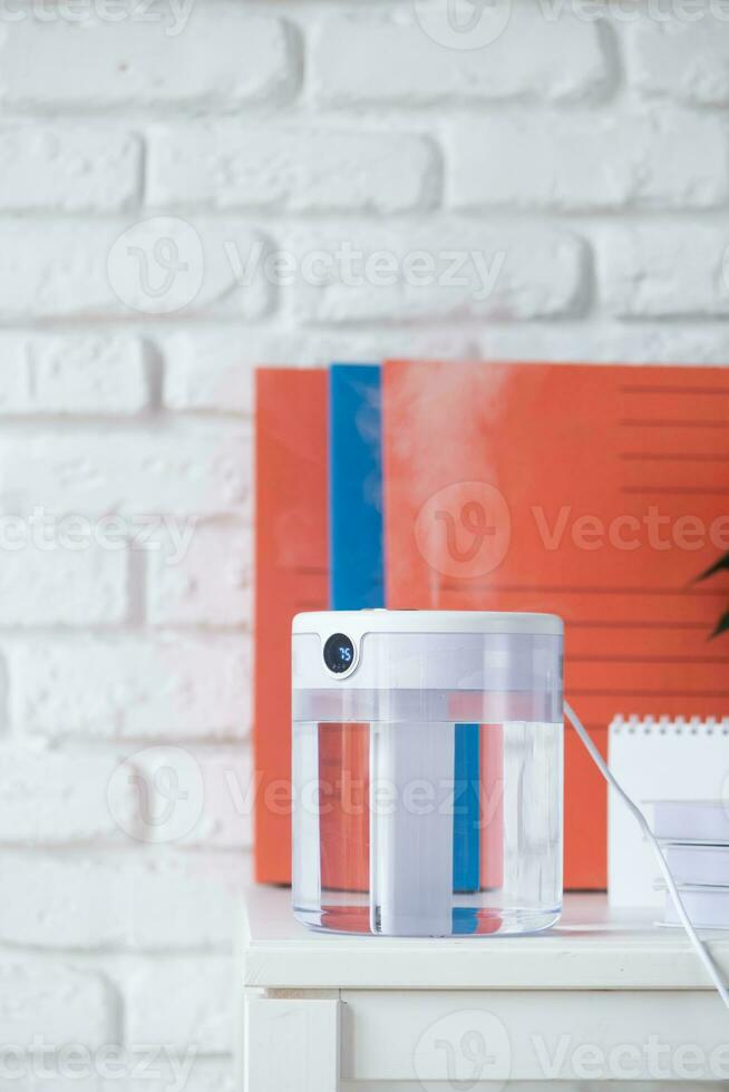 Modern air humidifier on table in living room or office . Space for text photo