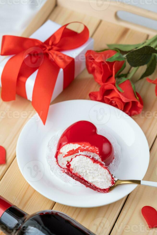 heart shaped glazed valentine cake and flowers on wooden tray photo