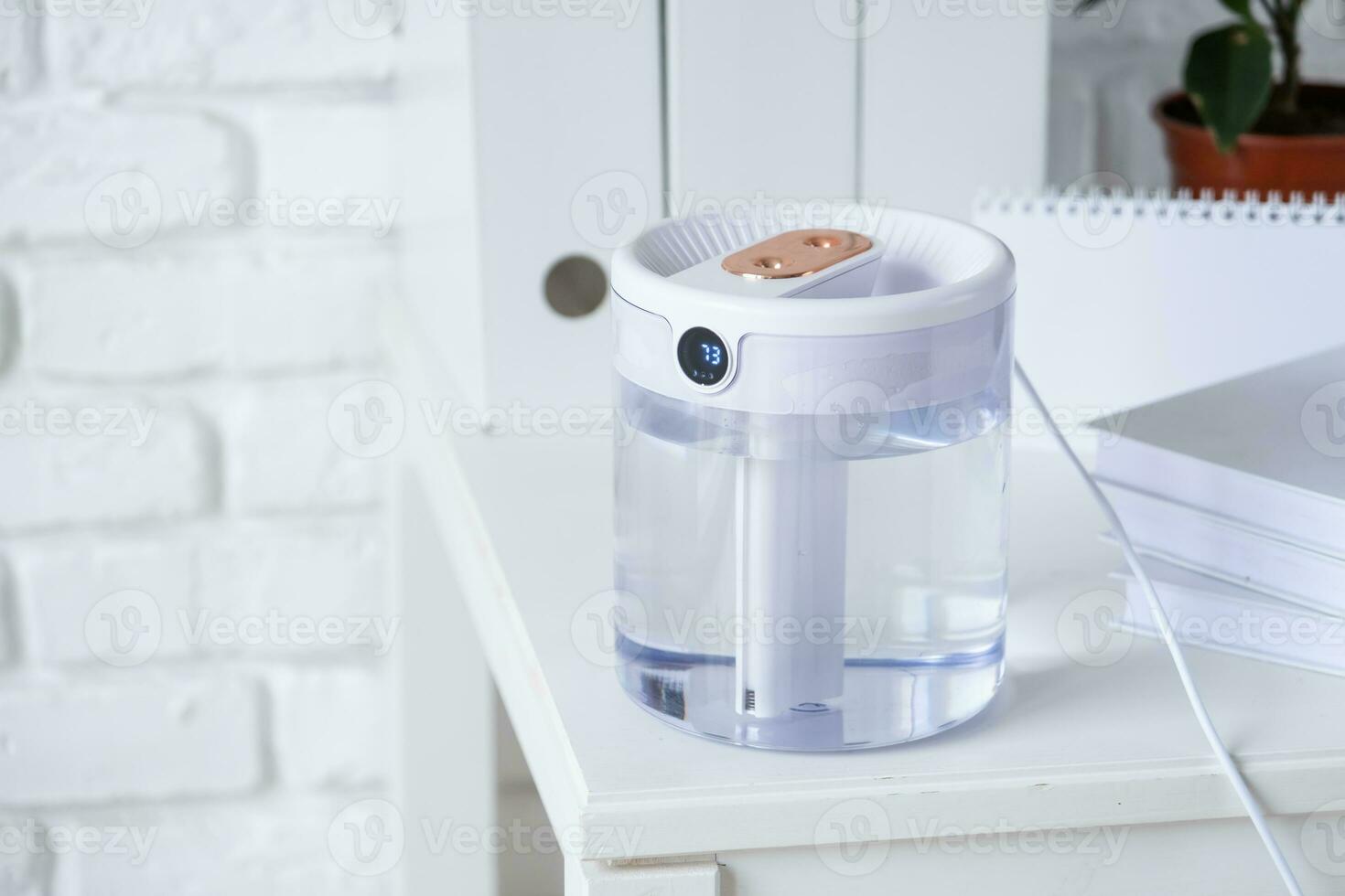 Modern air humidifier on table in living room or office . Space for text photo