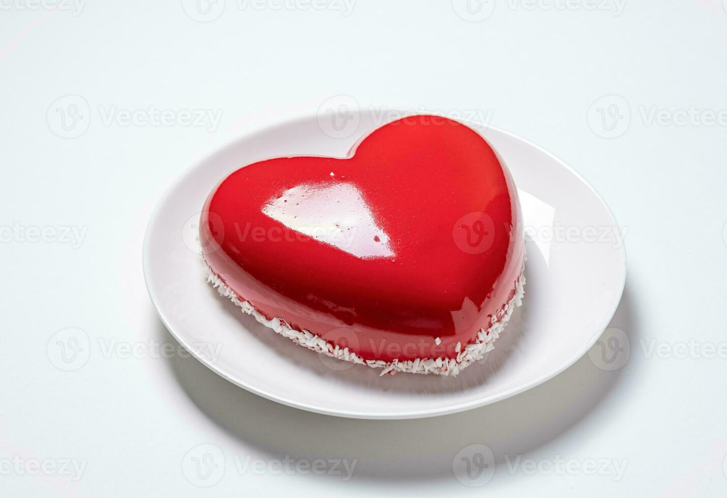 heart shaped glazed valentine cake on white plate on white background photo