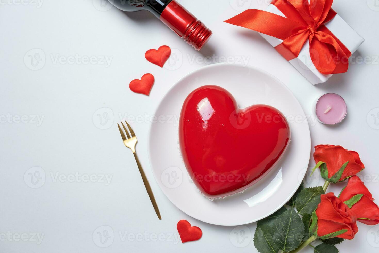 heart shaped glazed valentine cake, gift and champagne on white background photo