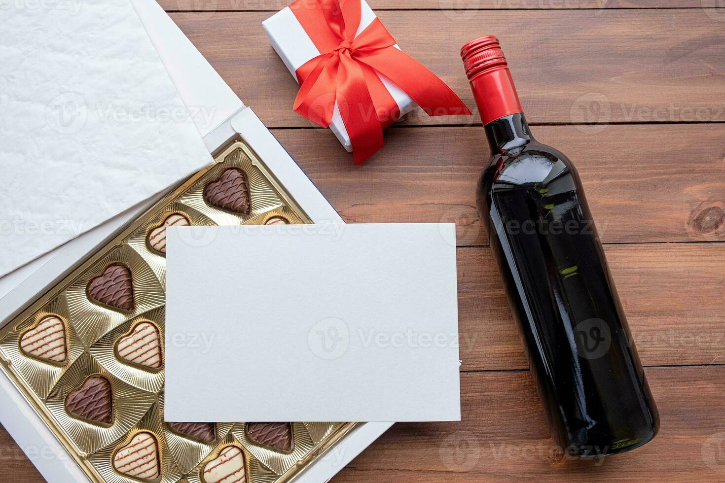 valentine sweet chocolate and red wine on wooden background photo