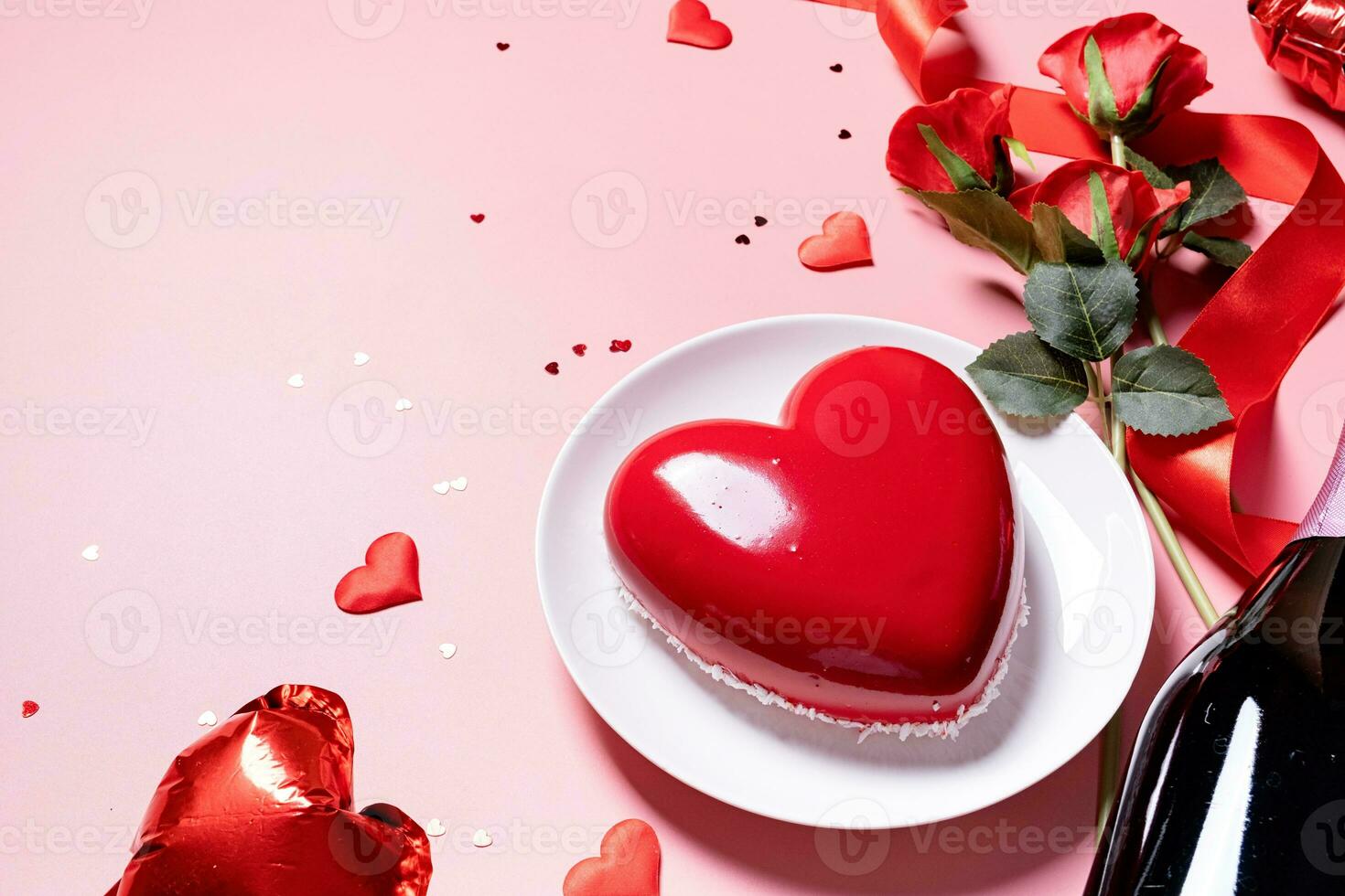heart shaped glazed valentine cake and flowers on pink background photo