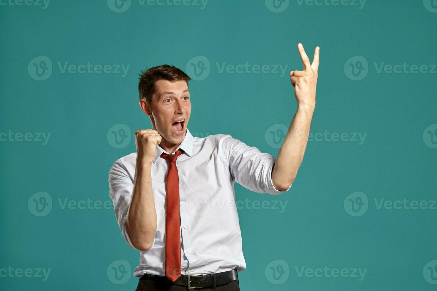 Portrait of a young brunet man posing in a studio against a blue background. photo