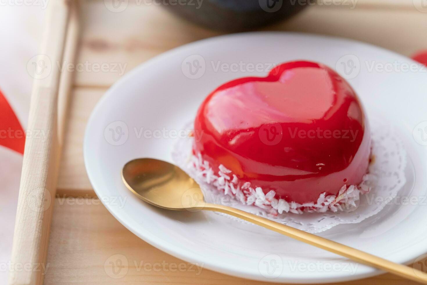heart shaped glazed valentine cake in bed on wooden tray photo