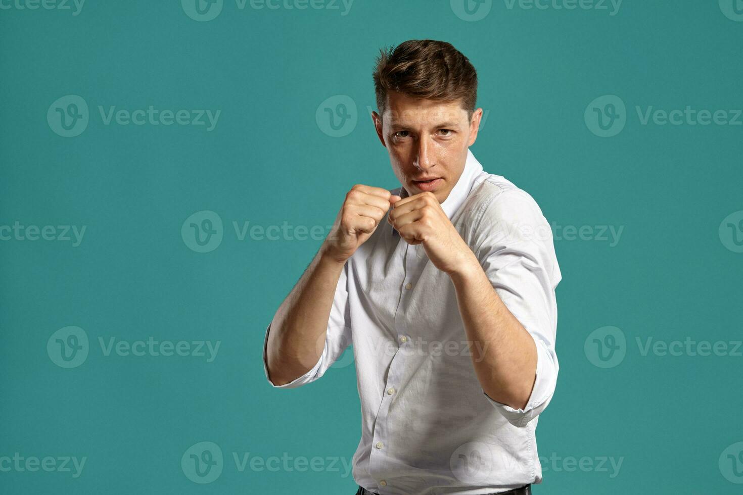 Portrait of a young brunet man posing in a studio against a blue background. photo