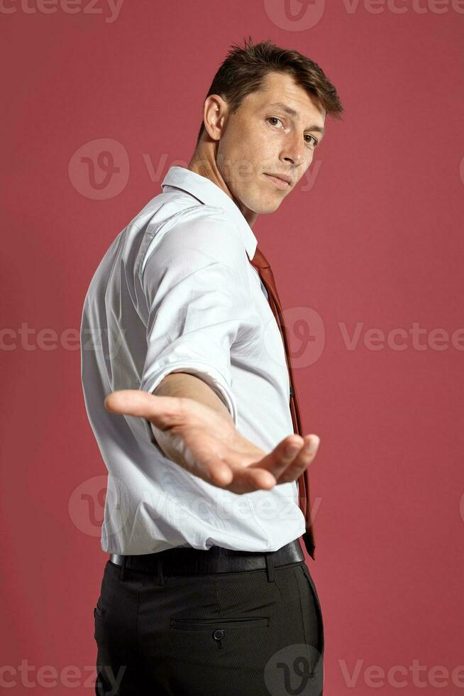 retrato de un joven moreno hombre posando en un estudio en contra un rojo antecedentes. foto