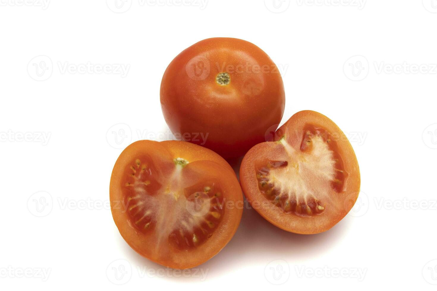 One whole tomato and one cut in half. Isolated on white background. The tomato is the fruit of the Solanum lycopersicum plant, which has culinary importance and is used as a vegetable. photo