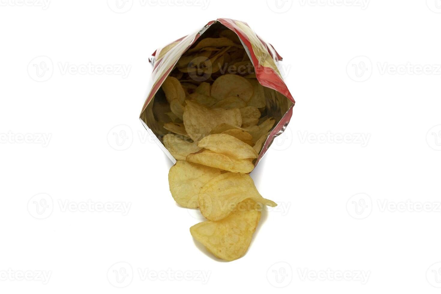 Bag of potato chips, open and front view. With potato chips inside and outside the bag. Isolated on white background. Selective focus. In Western countries, they are a very important part of the snack photo