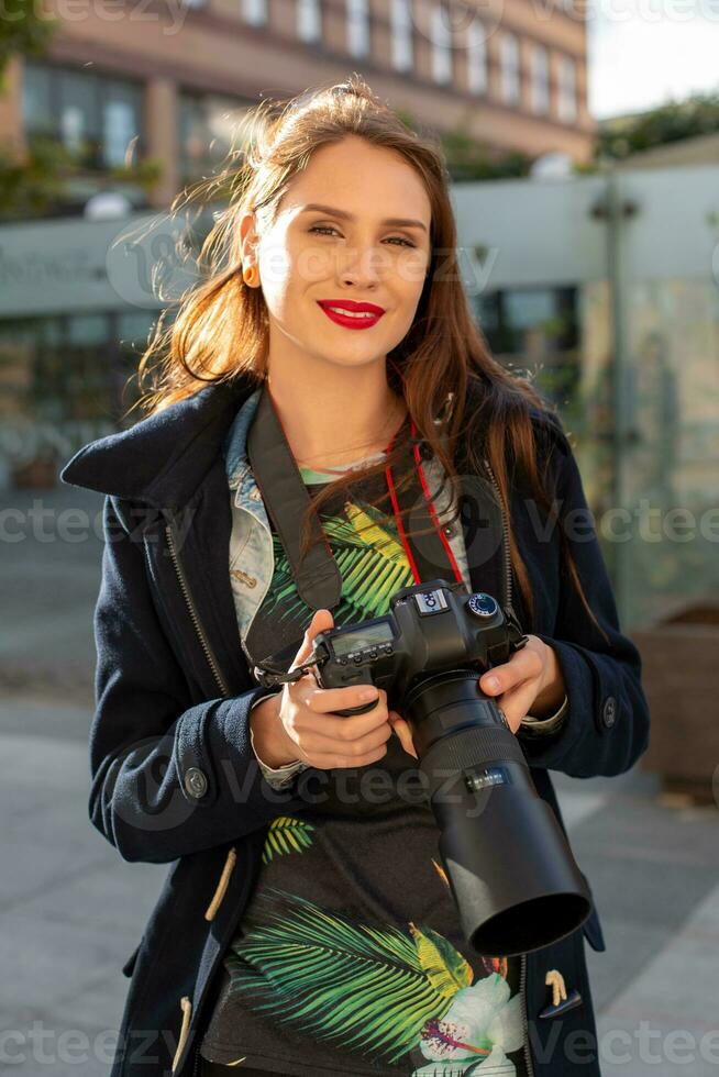 atractivo turista mujer fotógrafo con cámara, al aire libre en ciudad calle. foto
