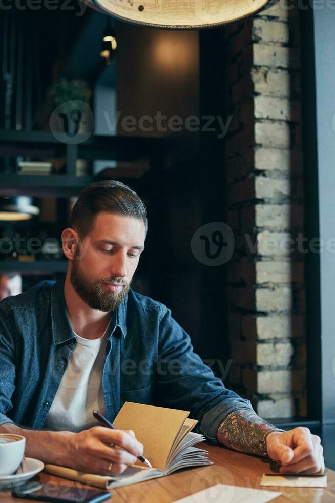 Man hand with pen writing on notebook on a wooden table. photo