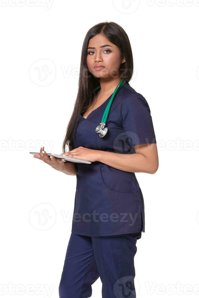 Close up portrait of young indian doctor woman with stethoscope around neck isolated on white background photo