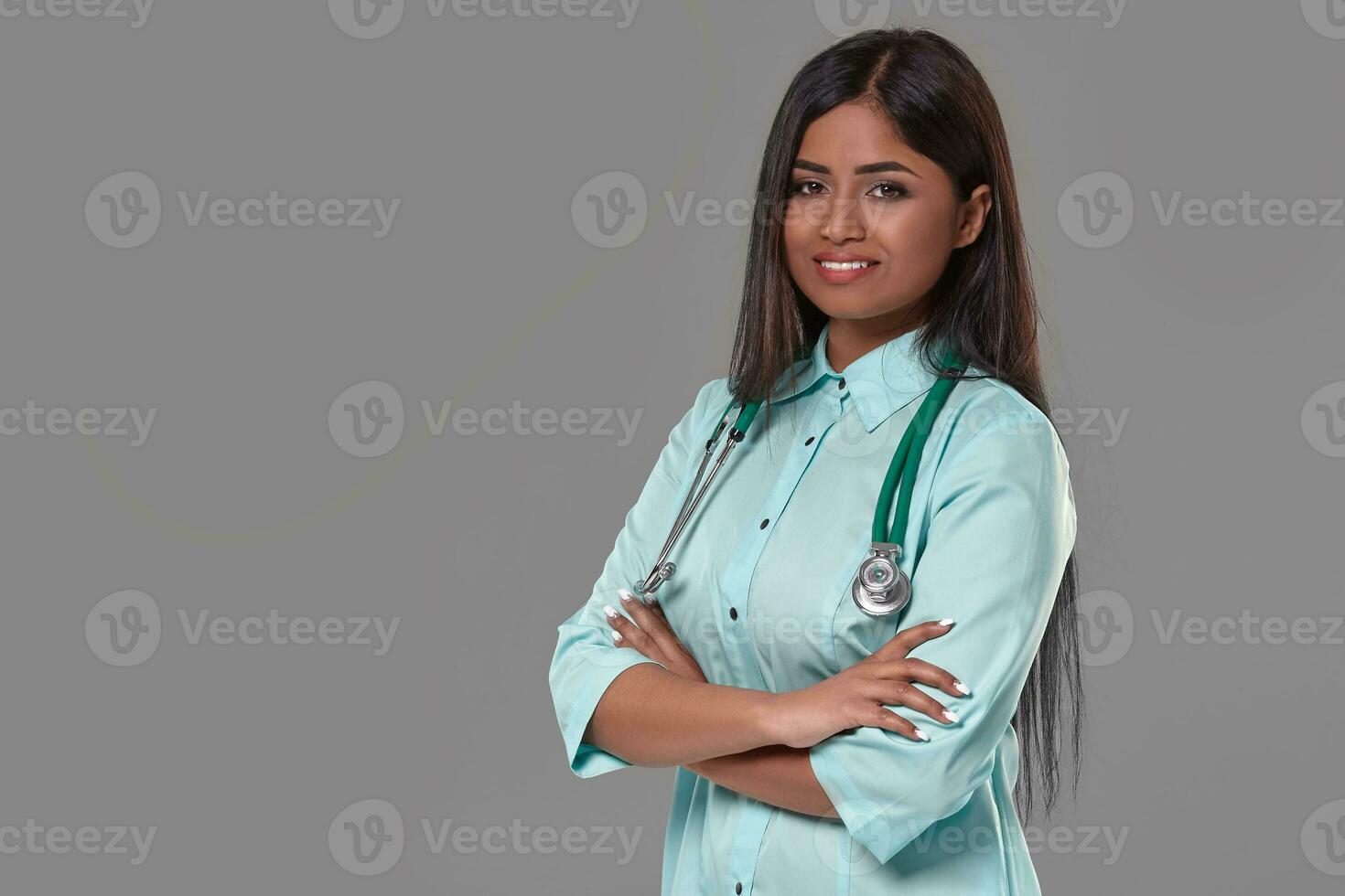 adorable indio hembra médico enfermero con estetoscopio en aguamarina vestir en gris antecedentes foto
