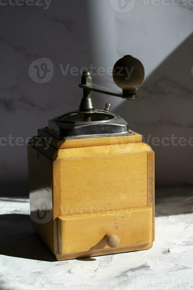 whole roasted coffee beans in the drawer of a vintage wooden coffee grinder photo