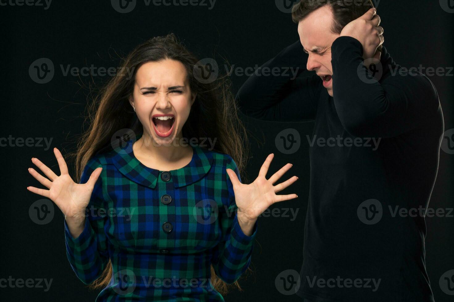 ouple having conflict, bad relationships. Angry fury woman screaming man closing his ears. photo