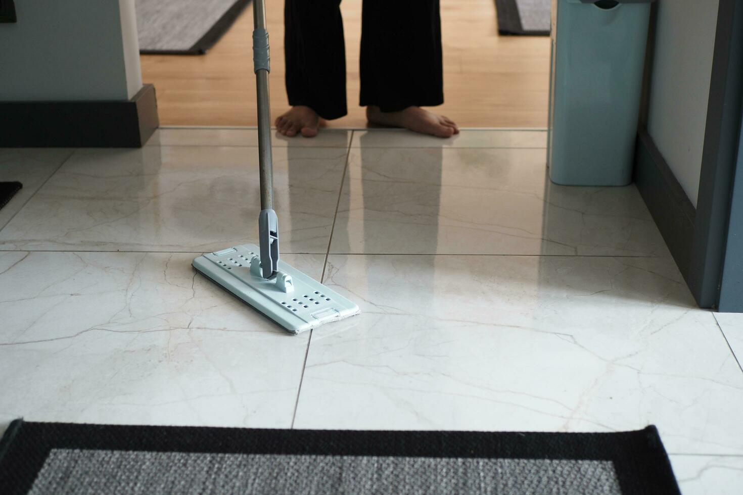 cleaning tiles floor with mop photo