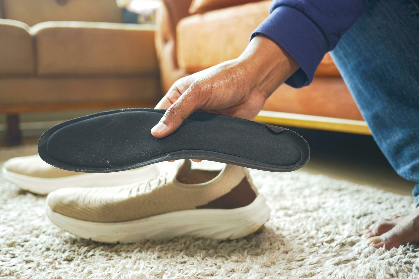 hombres mano poniendo ortopédico plantillas en Zapatos foto