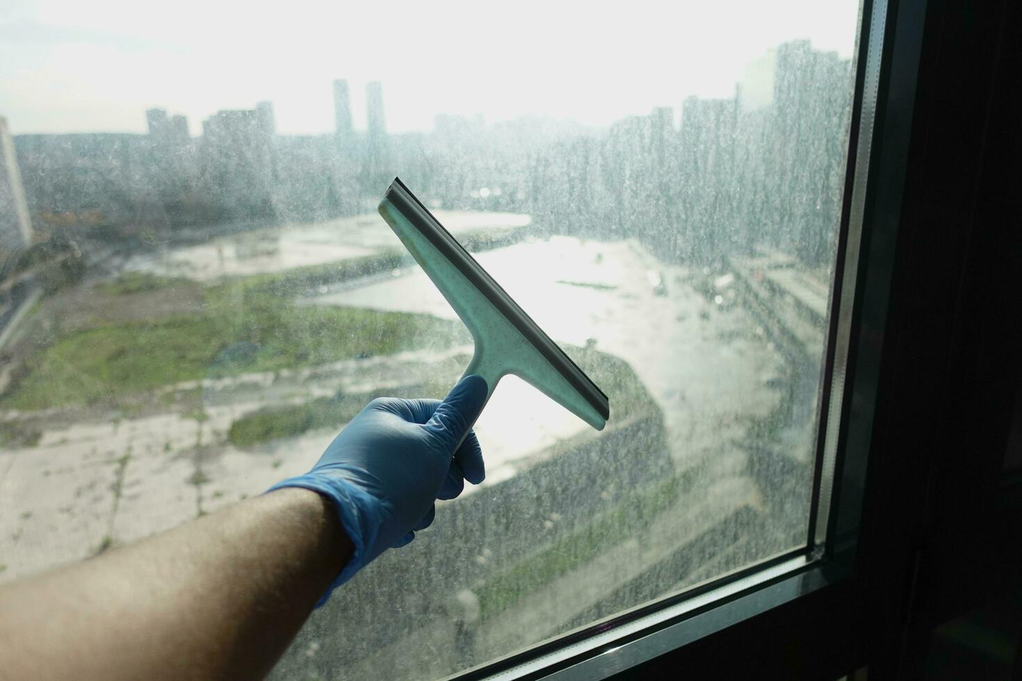 primer plano de la mano del hombre limpiando el cristal de la ventana foto