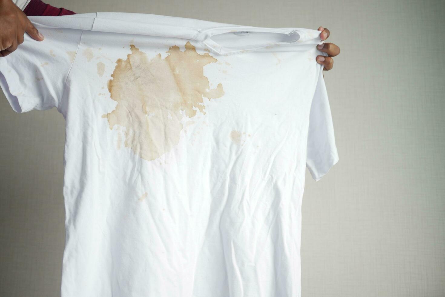 women holding white color dirty shirt, showing making stain photo