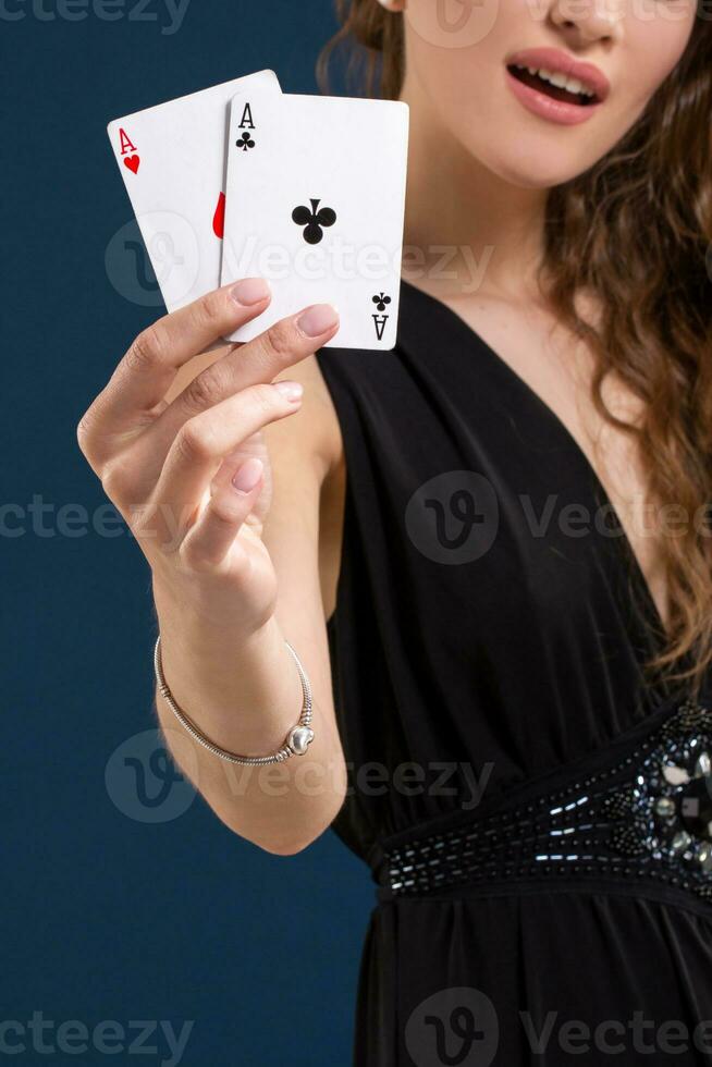 Woman holding two aces as a sign for poker game, gambling and casino. Close-up photo