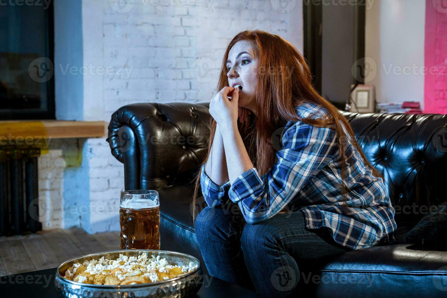 Young emotional attractive woman alone at home sofa couch watchi photo