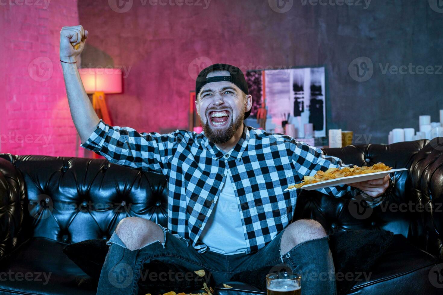 Young supporter man watching football game on television sitting photo