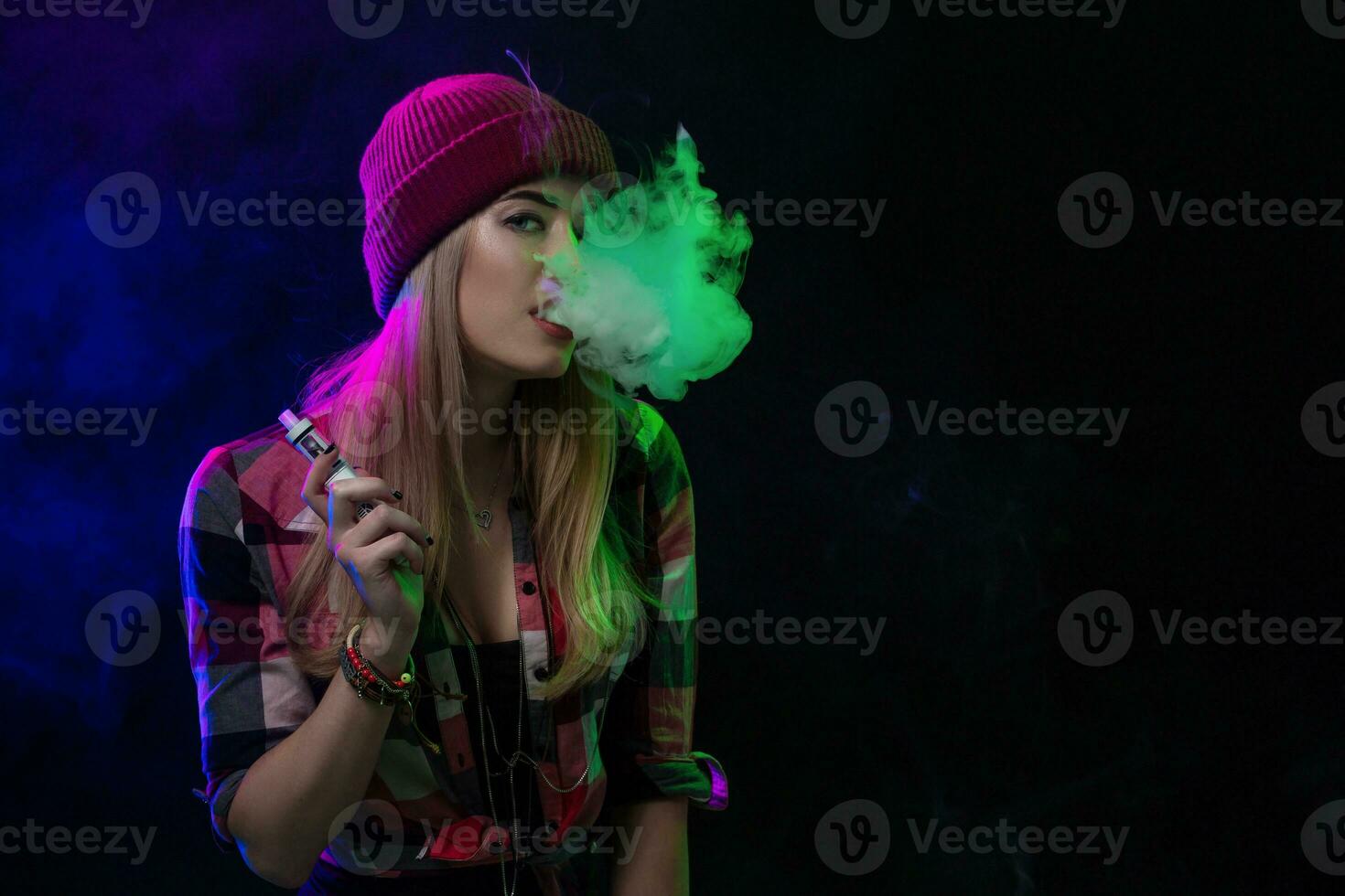 vaping muchacha. joven hipster mujer vape e-cig en negro antecedentes. hip hop estilo. estudio Disparo foto