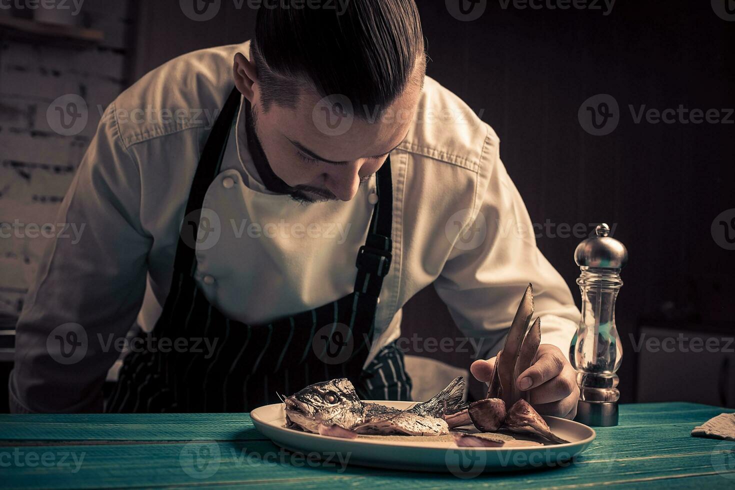 Hand over plate with fish. Cooked fish. Juicy fish on plate. photo