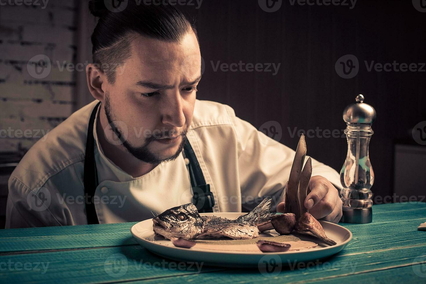 Hand over plate with fish. Cooked fish. Juicy fish on plate. photo