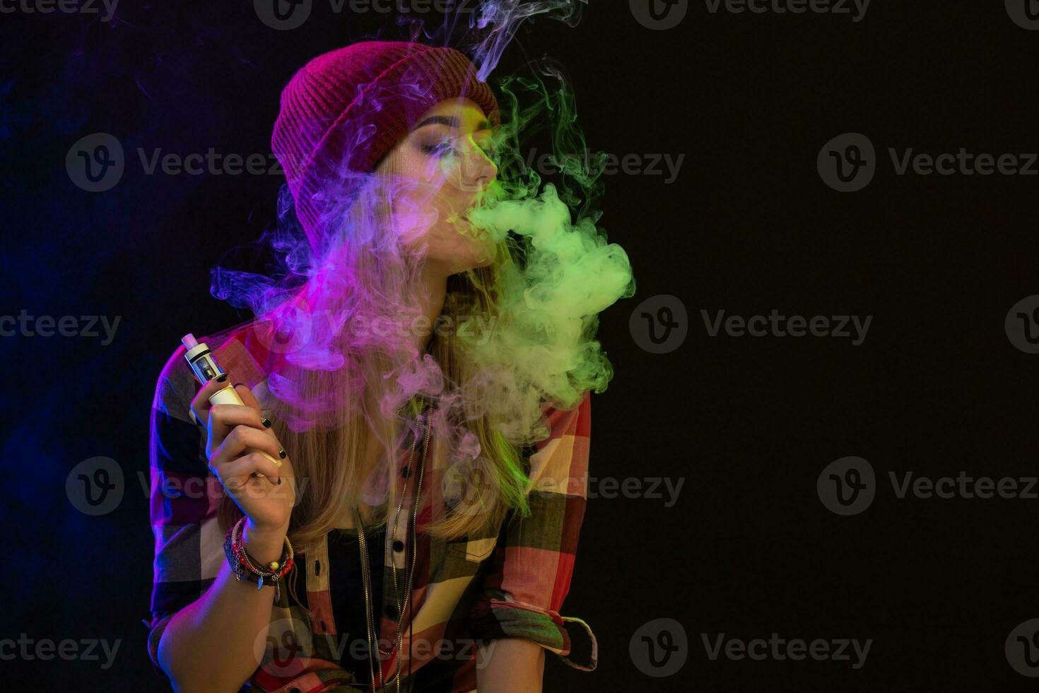 vaping muchacha. joven hipster mujer vape e-cig en estudio en negro antecedentes. hip hop estilo. cerca arriba. foto