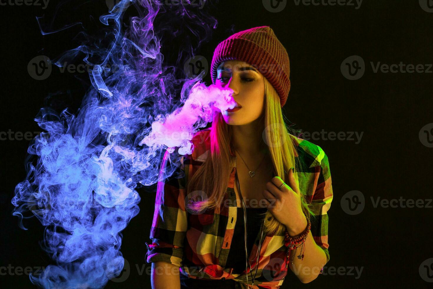 vaping muchacha. joven hipster mujer vape e-cig en estudio en negro antecedentes. hip hop estilo. cerca arriba. foto