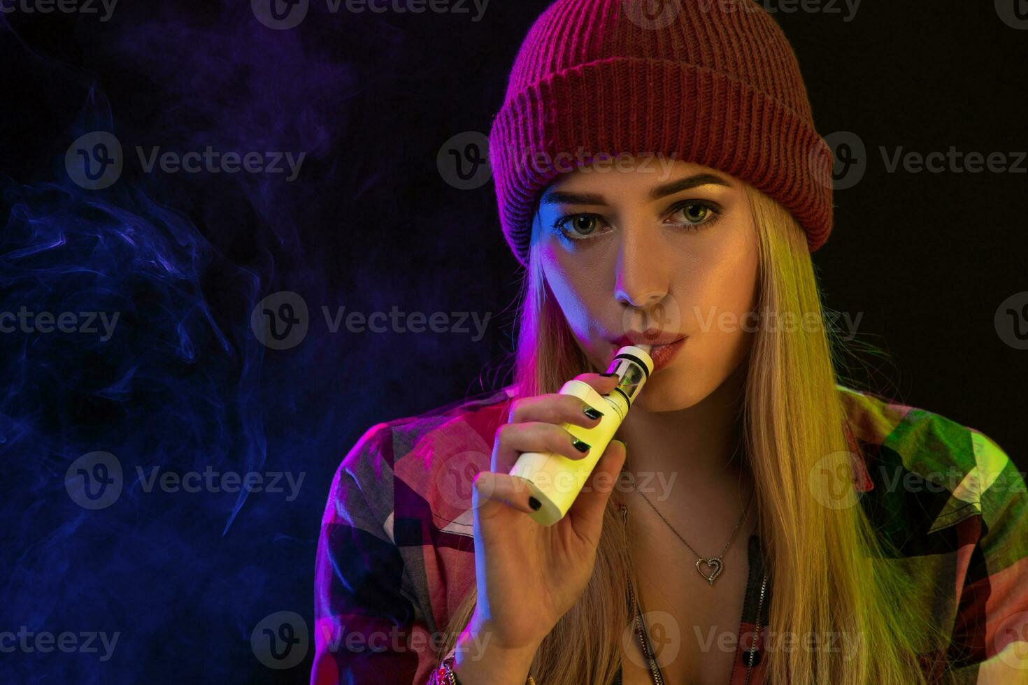 Portrait of young hipster vaping girl. Vapor concept. Vaping e-Cigarette. Close-up photo
