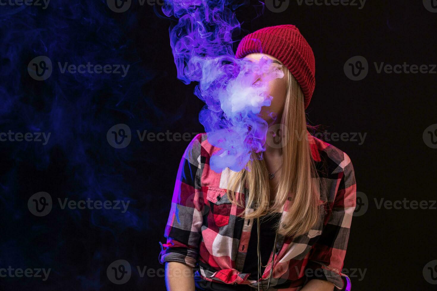 Vaping girl. Young hipster woman vape e-cig on studio on black background. Hip-hop style. Close up. photo