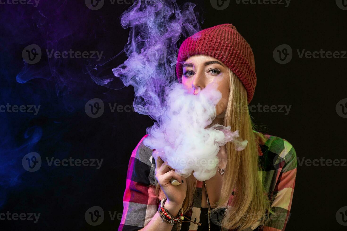 vaping muchacha. joven hipster mujer vape e-cig en estudio en negro antecedentes. hip hop estilo. cerca arriba. foto