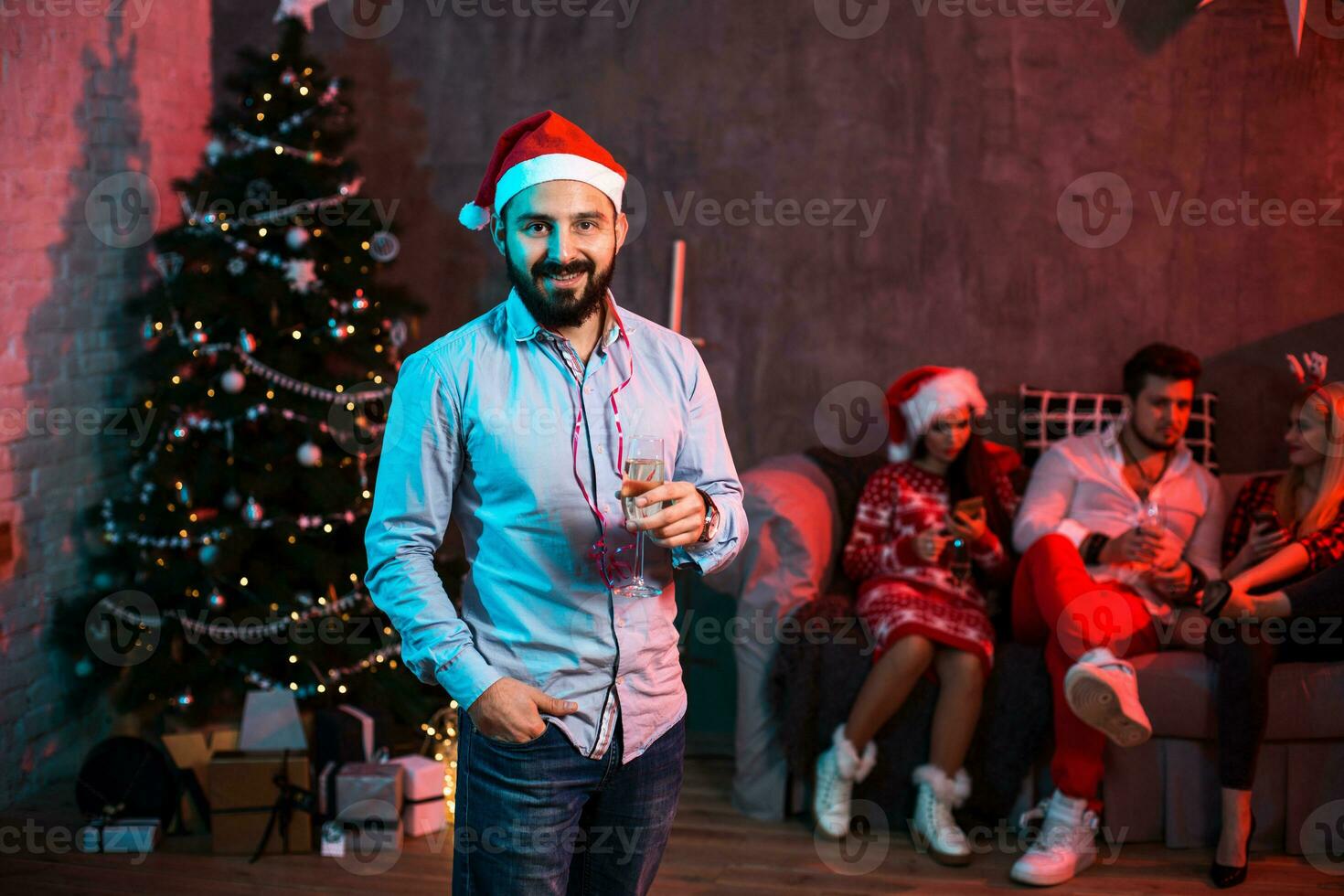 Navidad, Navidad, nuevo año, invierno, felicidad concepto - sonriente hombre en Papa Noel ayudante sombrero con un vaso de champán foto