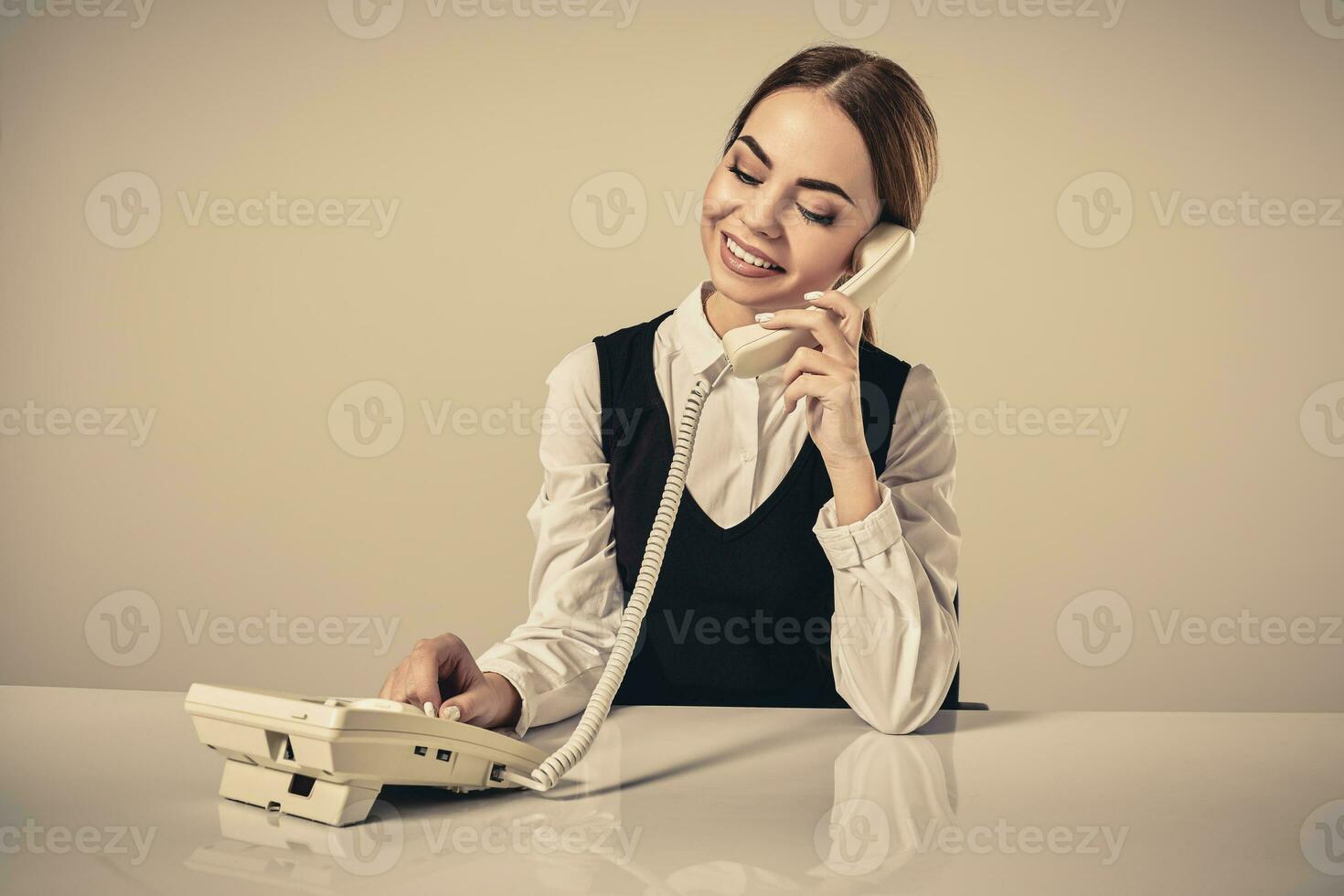 portrait of young secretary answering telephone photo