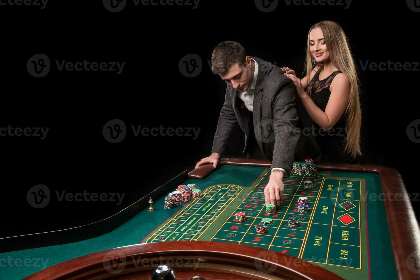 elegante Pareja a el casino apuesta en el ruleta, en un negro antecedentes foto