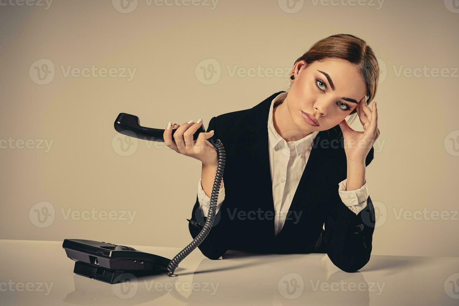 attractive dark-haired woman dressed in a black suit is sitting photo