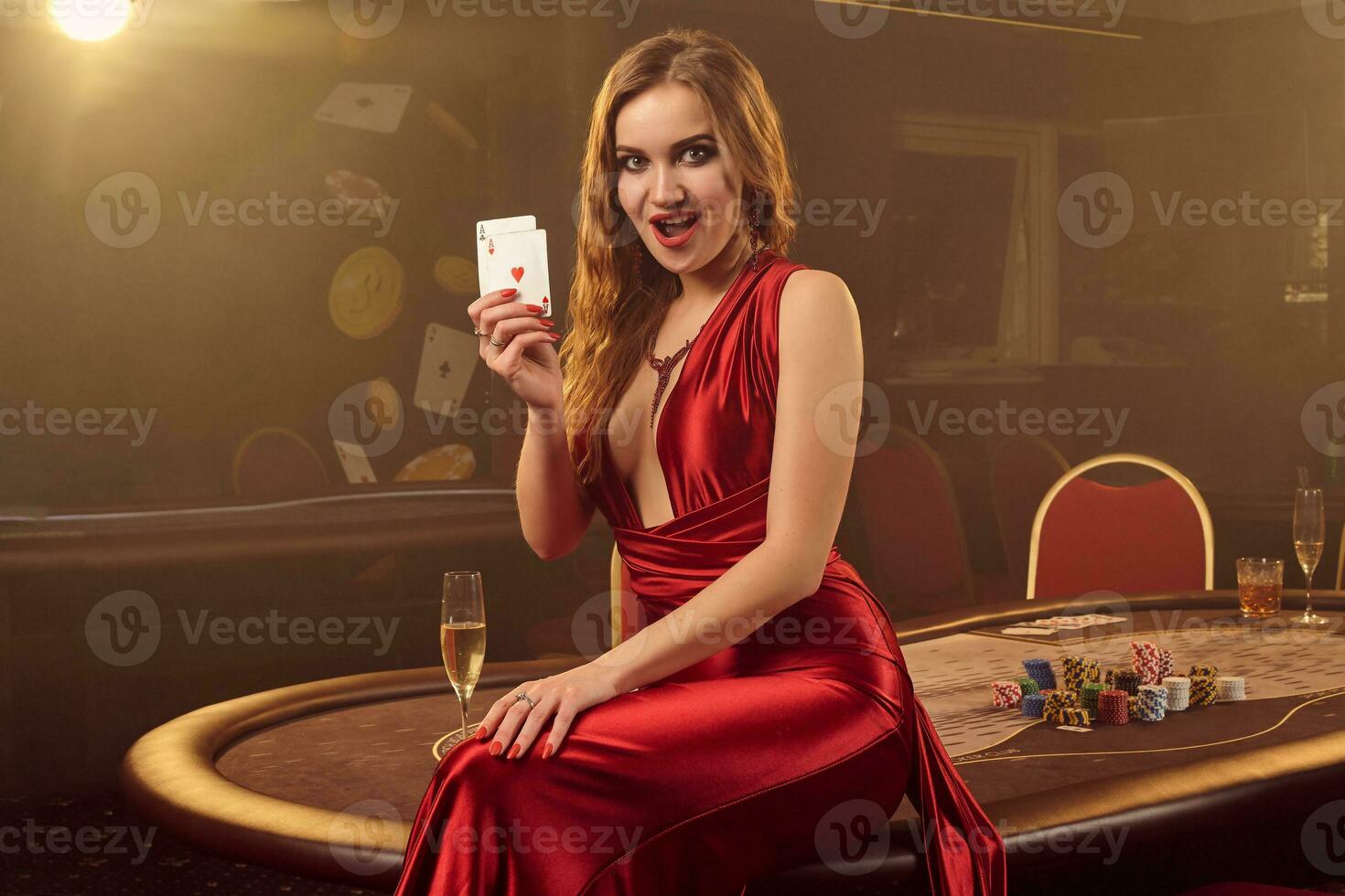Close-up shot of a beautiful woman posing against a poker table in luxury casino. photo